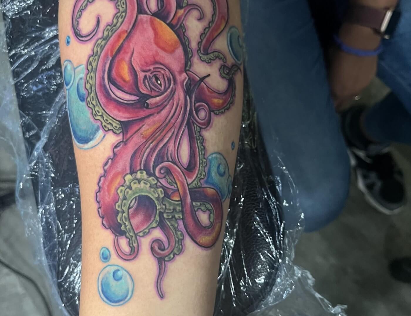 Octopus colored animal tattoo by Paper Airplane Jane at Iron Palm Tattoos & Body Piercing in downtown Atlanta, GA. We're open late night until 2AM during the week. Call 404-973-7828 or stop by for a free consultation.