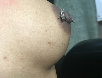 Side view of "Love" Barbell Nipple Piercing Installed at Iron Palm Tattoos & Body piercing in Atlanta Georgia. We like how the "O" in "love" is the nipple itself! Call 404-973-7828 or stop by for a free consultation with a body artist.