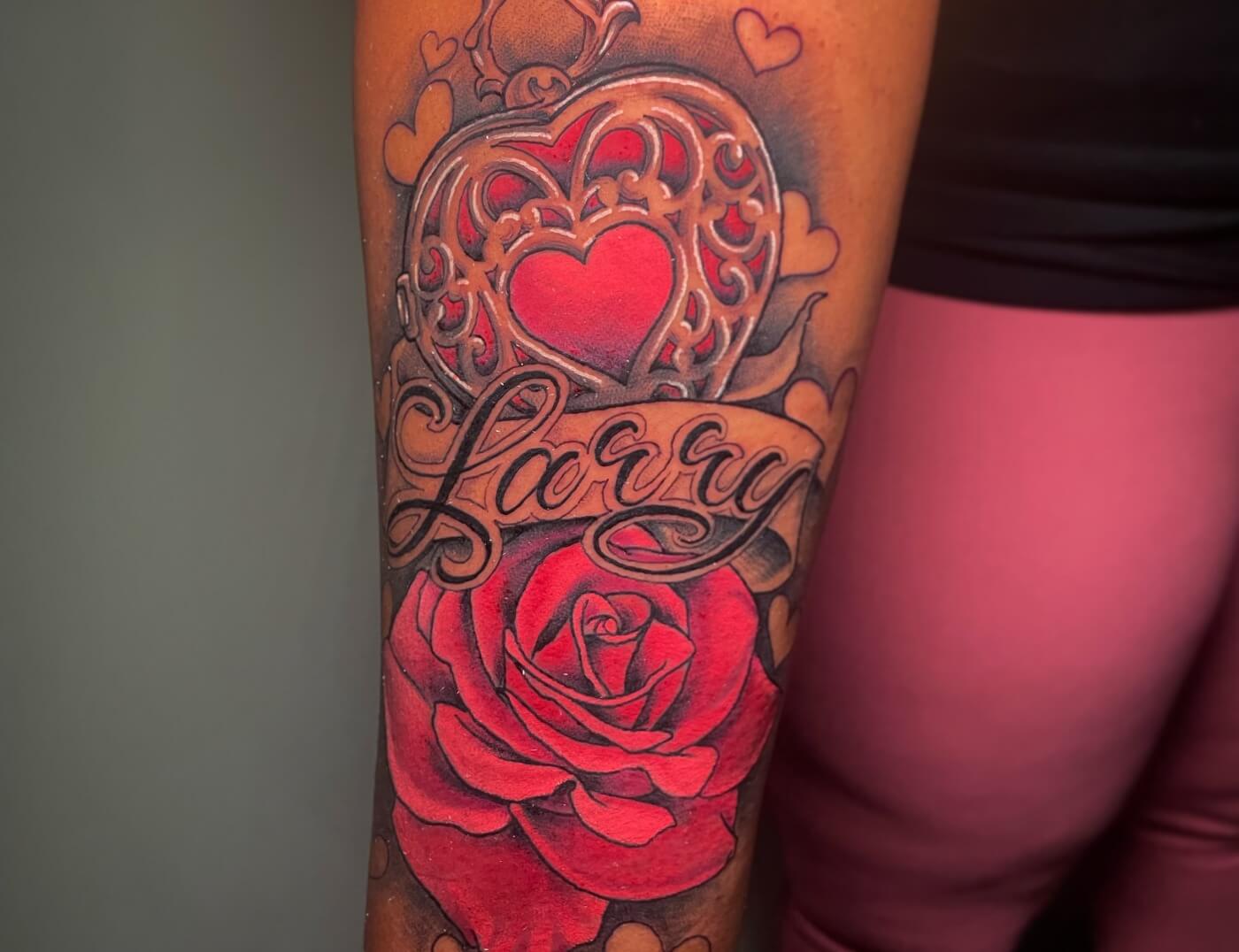 "I Love Larry" Red Rose & Heart Tattoo By Lyric The Artist At Iron Palm Tattoos in downtown Atlanta, GA. This also contains lettering script in a font designed by Lyric. We're open late night most nights until 2AM. Call 404-973-7828 or stop by for a free consultation with Lyric. Walk-Ins are welcome.