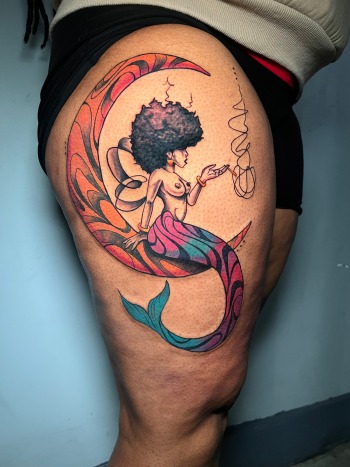 Afro Mermaid On Orange Crescent by Funk Tha World At Iron Palm Tattoos. Call 404-973-7828 or stop by for a free consultation with Funk.