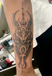 Anubis Tattoo By Funk Tha World At Iron Palm Tattoos In Atlanta, GA. Anubis, the Egyptian God, is a symbol of protection, guidance, or transformation. For some he is also a symbol of judgement. Call 404-973-7828 or stop by for a free consultation with Funk. Walk-ins are always welcome.
