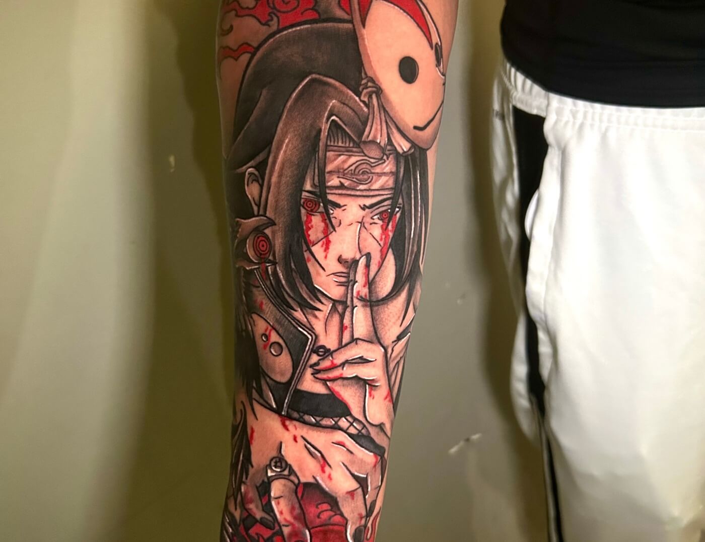 Itachi Uchiha Manga Anime Tattoo In black & red ink by Lyric TheArtist At Iron Palm Tattoos in south downtown Atlanta, GA. is a character in the Naruto manga and anime series created by Masashi Kishimoto. Itachi is the older brother of Sasuke Uchiha and is responsible for killing all the members of their clan... sparing only Sasuke. Call 404-973-7828 or stop by for a free consultation with Lyric or another Iron Palm Tattoos client. Walk Ins are welcome.