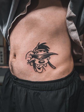 Maximilian "Max" Goof Black & Grey cartoon tattoo by Choze at Iron Palm Tattoos in downtown Atlanta, GA. Max is a beloved Disney character in the movie "A Goofy Movie". We're open late night til 2AM. Call 404-973-7828 or stop by for a free consultati
