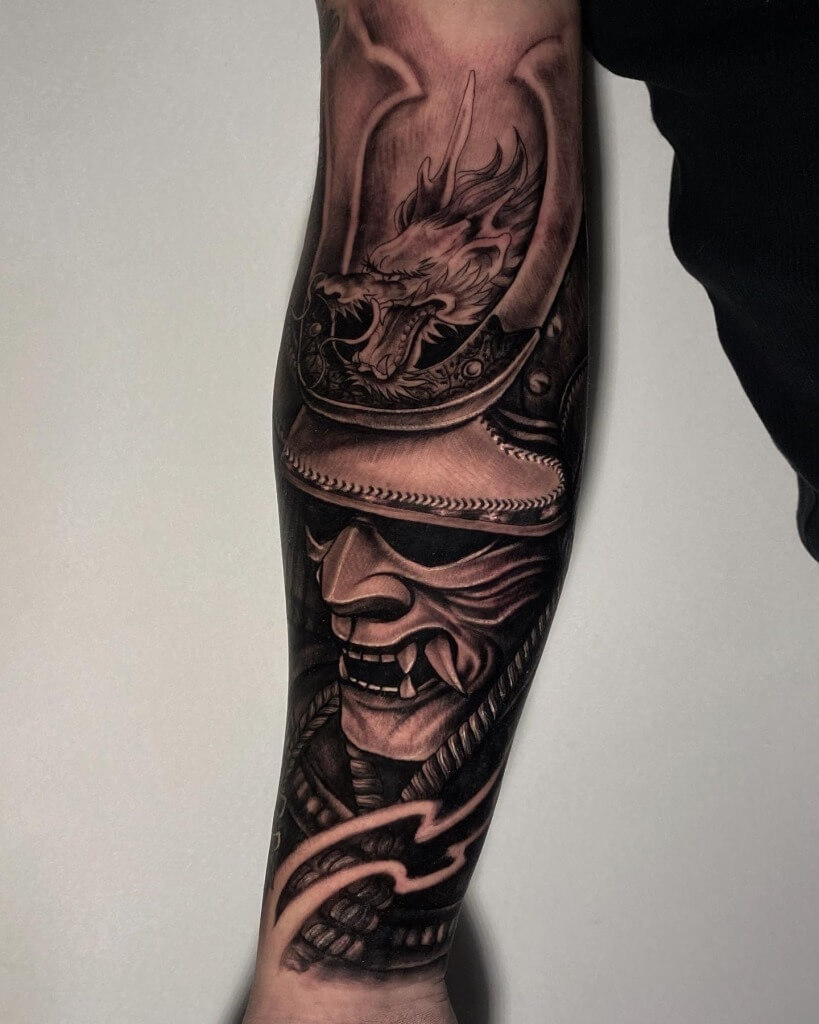 Samurai Mask Black & Grey Photo Realism Tattoo by Rene Cristobal, a guest Artist At Iron Palm Tattoos.. Samurai tattoos symbolize loyalty, honor, courage, and perseverance. Rene is available for booking Sept 11th - 18th, 2023 at Iron Palm. We're open late til 2AM and consultations are free. Call 404-973-7828. Walk-ins are welcome.