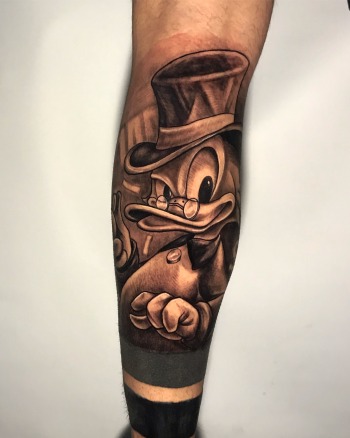 "Scrooge McDuck" Black And Grey Tattoo By Rene Cristobal, A Guest Artist At Iron Palm Tattoos. Rene is a renowned artist from Vision Tattoo Studio in Concepcion, Chile. Scrooge is a imaginative combination of Andrew Carnegie and fictional character Ebenezer Scrooge from a Andrew Dicken's classic "A Christmas Carol". The Disney character is immensely rich and extremely sharp in business decisions. These tattoos represent wealth, success, and prosperity. We're open late night until 2AM most nights. Call 404-973-7828 or stop by for a free consultation. Walk-Ins are welcome.