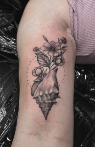 Conch Seashell With Flowers in Bloom Blackwork Tattoo By Choze at Iron Palm Tattoos in downtown Atlanta, Georgia. Conch shells symbolize fertility as the flowers and plant life on this tattoo depict. Our most senior artist, Choze specializes in fine line blackwork tattoos but has mastered many other styles. We're Atlanta's only late night tattoo shop. Call 404-973-7828 or stop by for a free consultation. Walk Ins are welcome.
