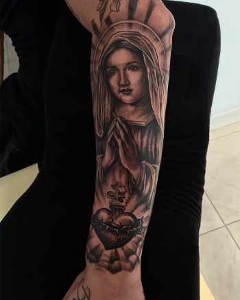 Madonna Blessing Hearts Black & Gray Photo Realism Portrait Tattoo By Rene Cristobal, A Guest Artist At Iron Palm Tattoos. The Madonna is a representation of Mary praying. The word "Madonna" comes from the Italian "ma donna," which means "my lady". Although usually depicted with baby Jesus it is also popular to see Mary praying or blessing something. Rene comes to us from Vision tattoo studio in Concepcion, Chile and is available for booking Sep 11th - Sept 18th 2023. We're open late night until 2AM. Call 404-973-7828 or stop by for a free consultation. Walk Ins are welcome.