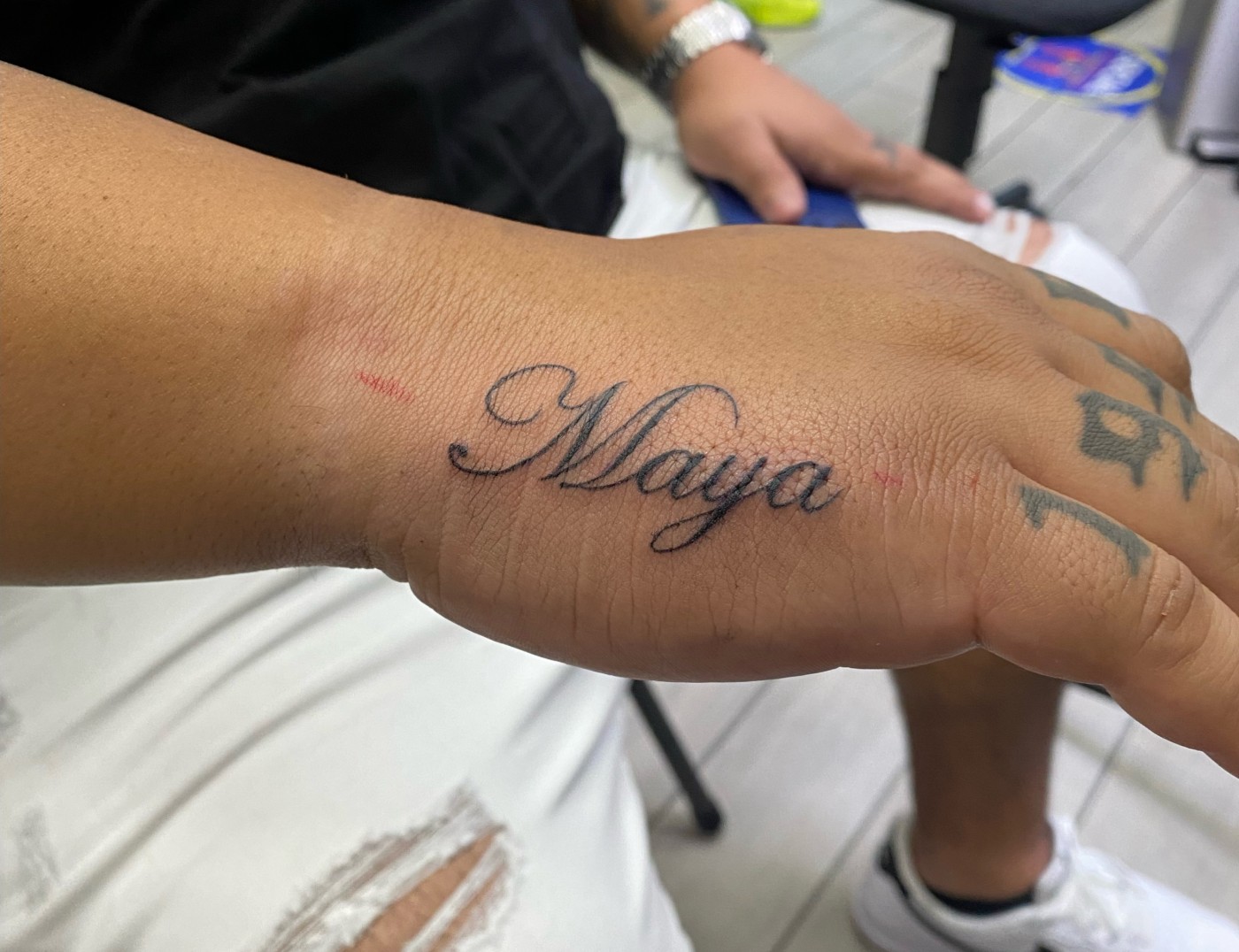 "Maya" Fine Line Lettering Script Tattoo By Rene Cristobal, a guest tattoo artist at Iron palm Tattoos. Script tattoos are a popular of memorializing friends and family we want to keep close to us at all times. Rene comes to us from Vision Tattoo Studio in Concepcion, Chile. He is available for booking on September 11th, 2023. Call 404-973-7828 or stop by for a free consultation. Walk Ins are welcome.