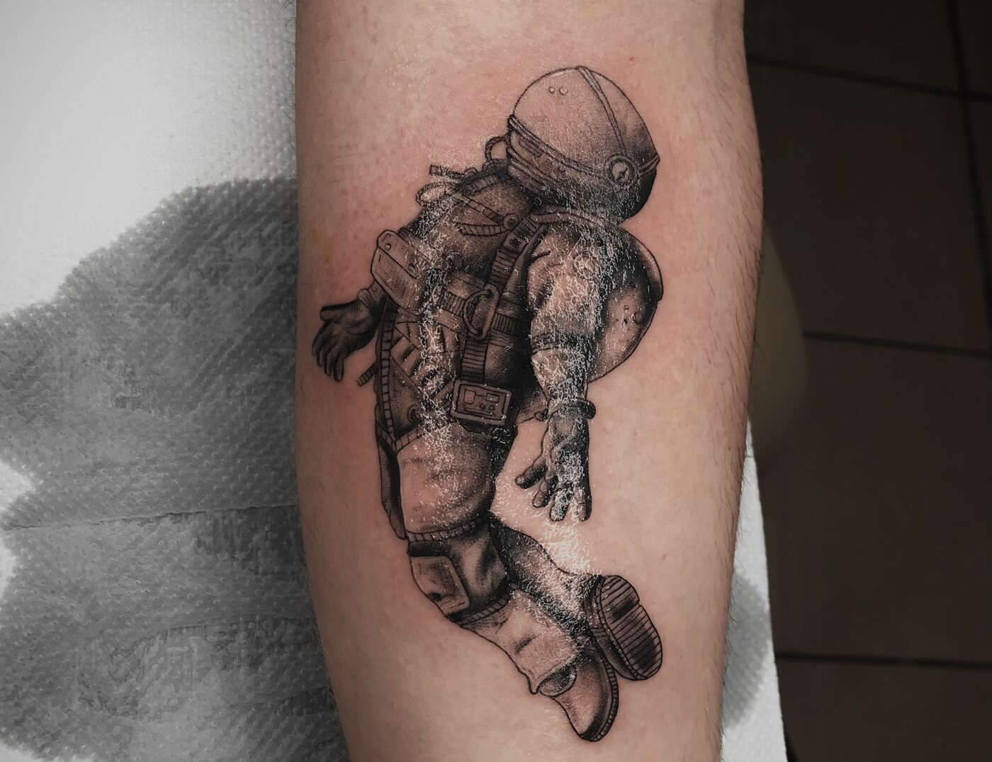 Astronaut Blackwork Tattoo By Rene Cristobal At Iron Palm Tattoos. We love how the astronaut is floating free on his arm. Call 404-973-7828 or stop by for a free consultation. Open til 2AM. Walk-ins are welcome.