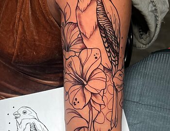 Fine Line Bird & Lotus Flower Tattoo By Funk Tha World. Funk is a senior artist at Iron Palm Tattoos. This intricate artwork seamlessly blends delicate lines to portray the beauty of a bird alongside the elegance of a lotus flower. The fusion of fine lines actually make you imagine more details than are present. What do you think? Let us know in the comments. If you're interested in acquiring a unique and expertly crafted tattoo, contact Funk at 404-973-7828 to schedule a free consultation.