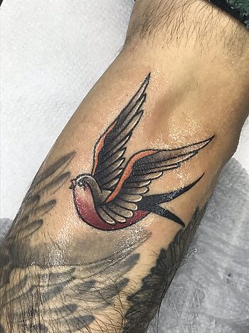 Swallow Bird Flying Black & Gray With Red Color Tattoo By Rene Cristobal. Swallow tattoos are a popular US Navy tradition. Each swallow represents 3500 miles traveled by sea. Iron Palm is Atlanta's only late night tattoo shop. Call 404-973-7828 or stop by for a free consultation. Walk ins are welcome.