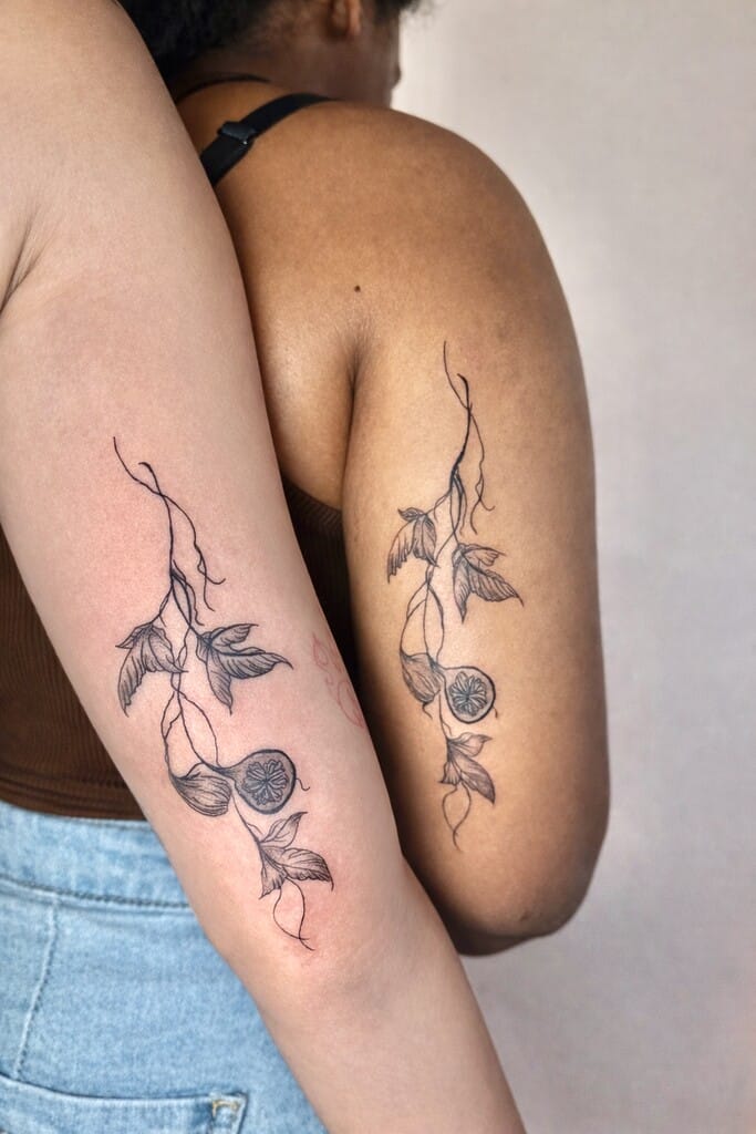 fine line black and gray floral vine matching arm tattoos